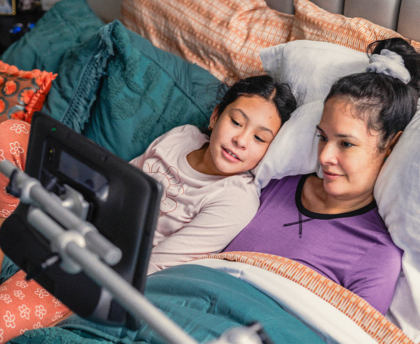 A woman with ALS using a Tobii Dynavox ConnectIT Floorstand mount to access her speech generating device while communicating with her daughter